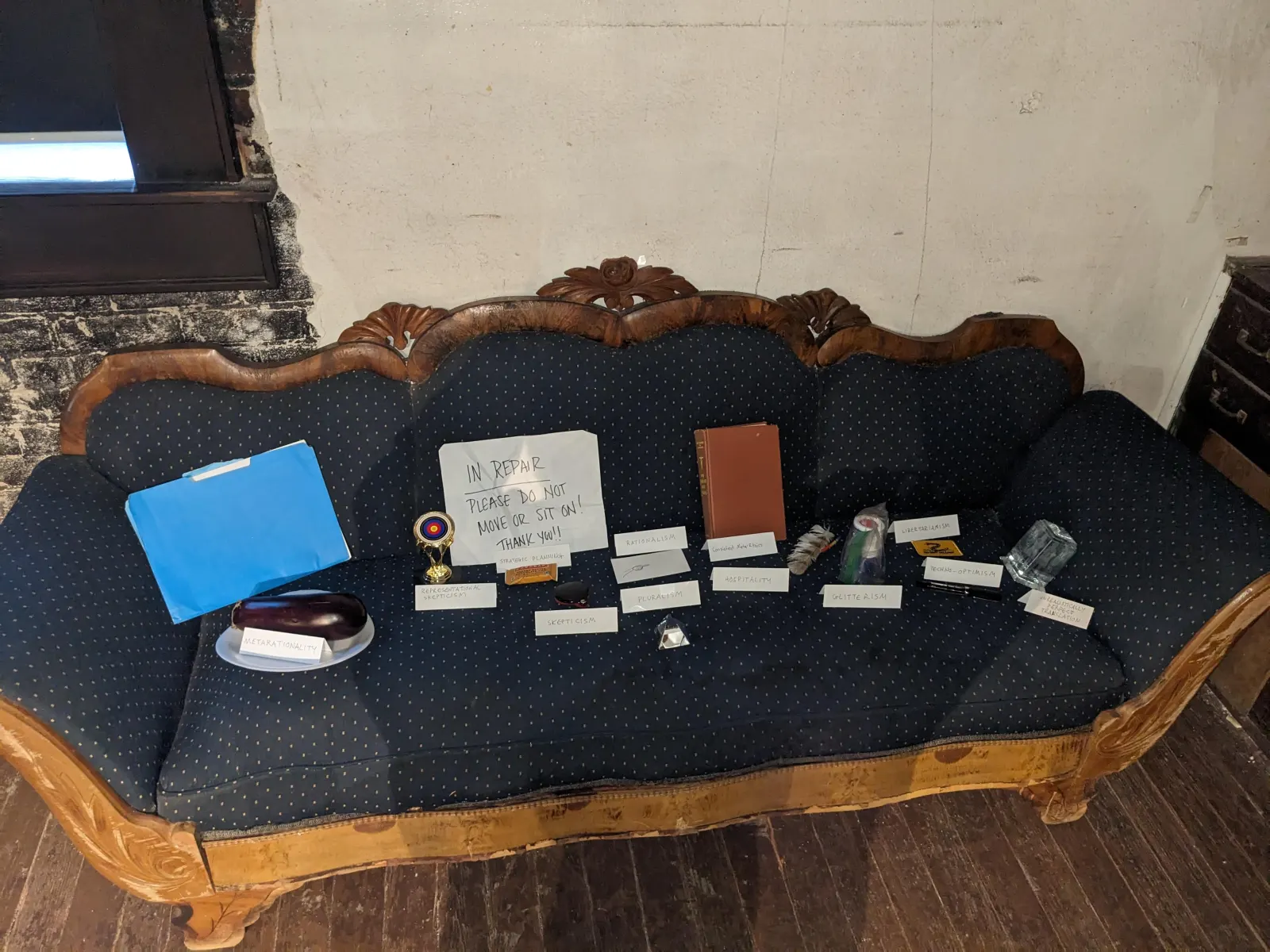 A wide view of ideology objects and their labeled tent signs arranged across the altar.