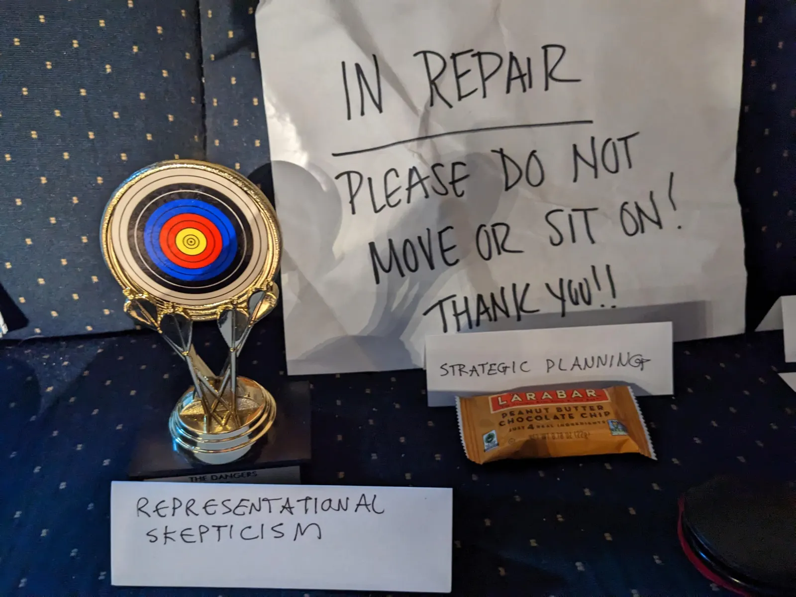 A target-shaped object on the Ideology Altar with a tent sign labeled Representational Skepticism.