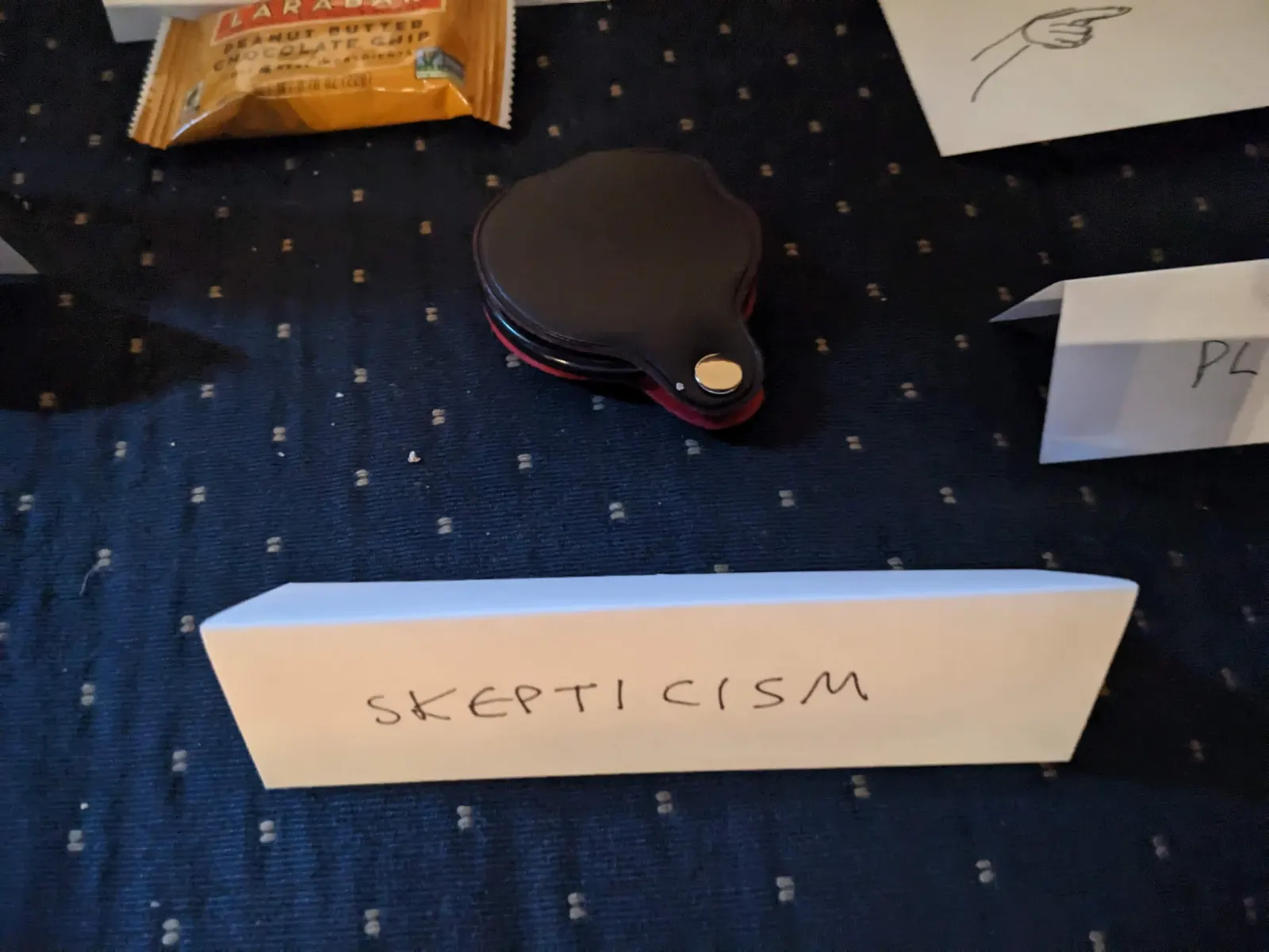 An object on the Ideology Altar with a tent sign labeled Skepticism.