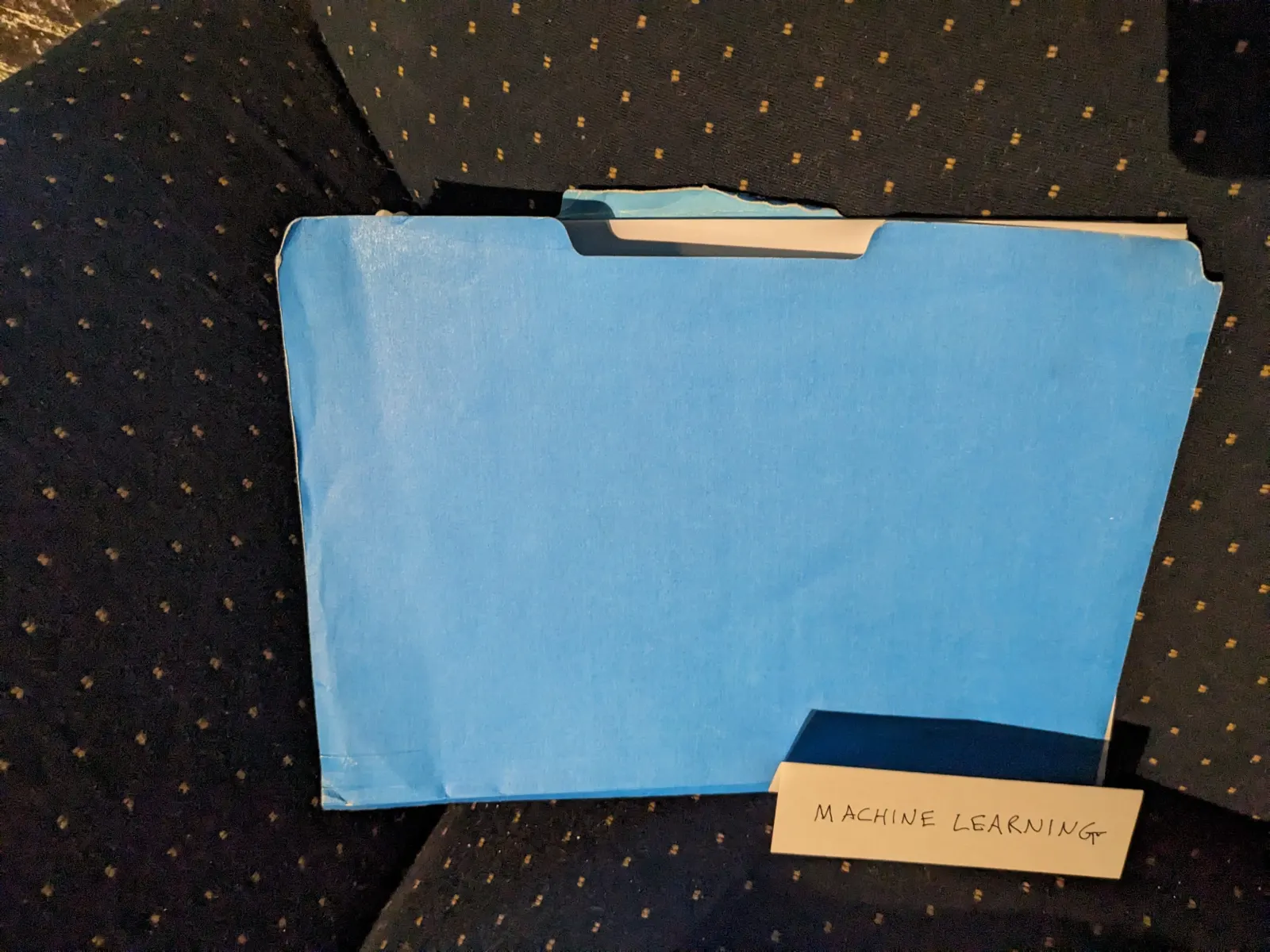 A blue folder on the Ideology Altar with a tent sign labeled Machine Learning.