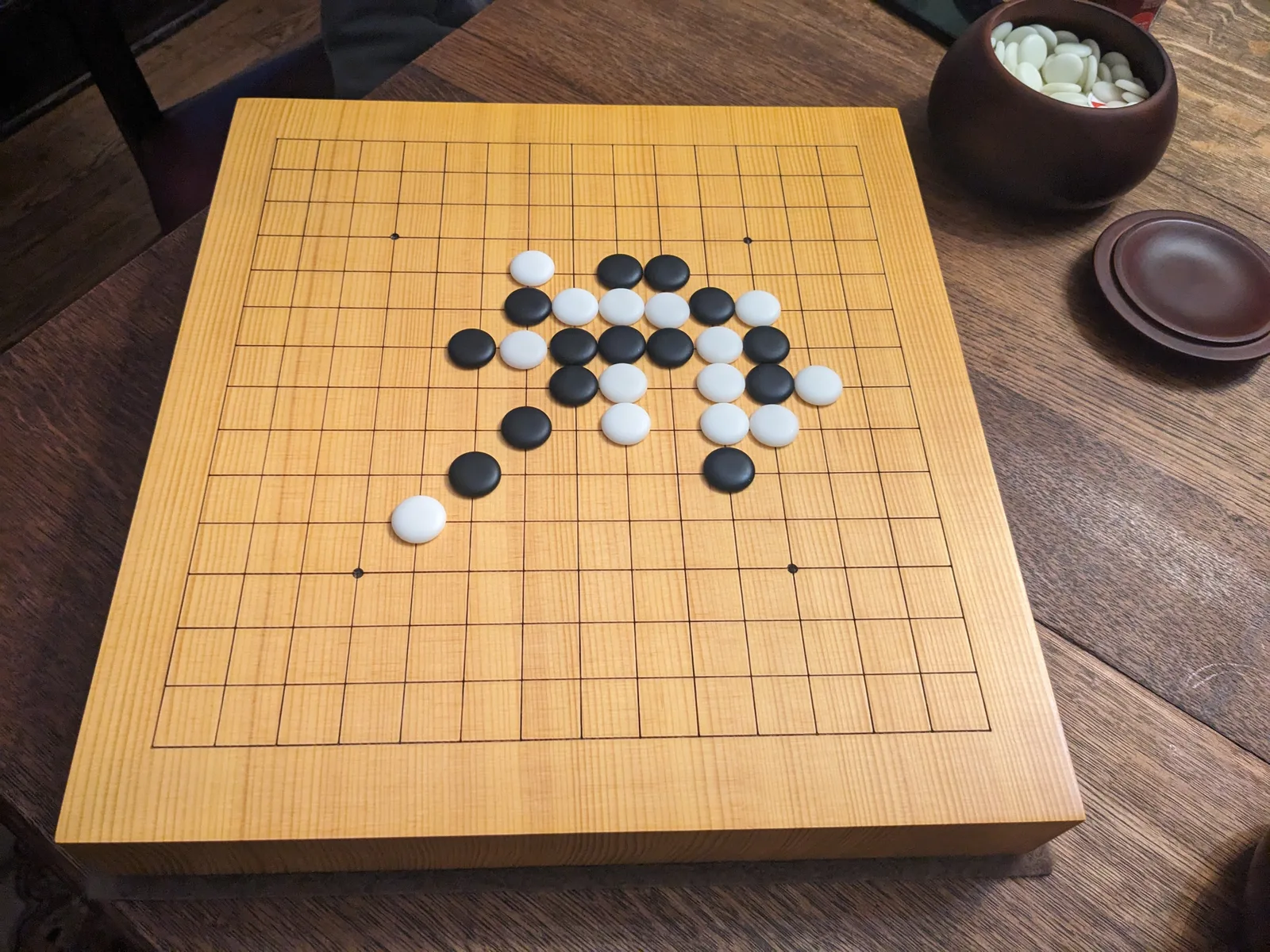 Black and white stones arranged in a Go-Moku game on Fluidity Forum's wooden Go board.